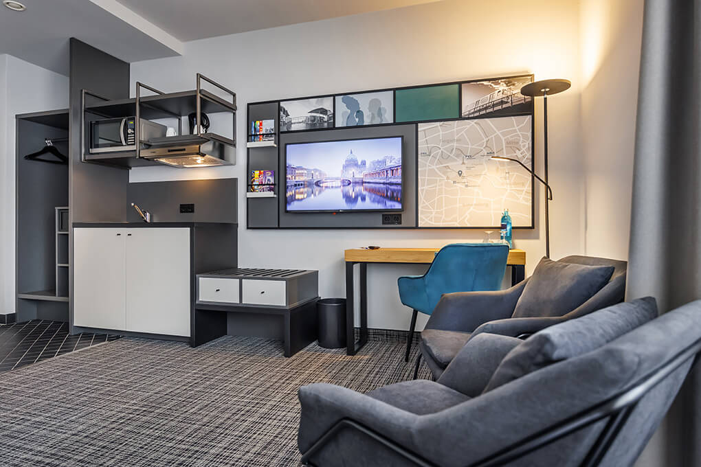 Flat-TV und Sitzecke im Einzelzimmer des Hotel Lützow in Berlin-Tiergarten