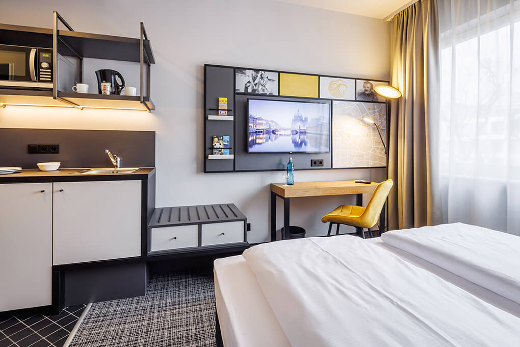 TV und Arbeitsbereich im Zweibettzimmer in Berlin