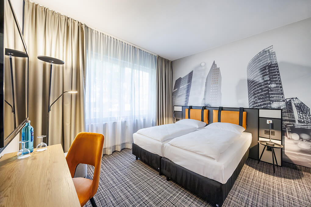 Zwei Betten mit gelbem Kopfteil im Hotel Lützow in Berlin